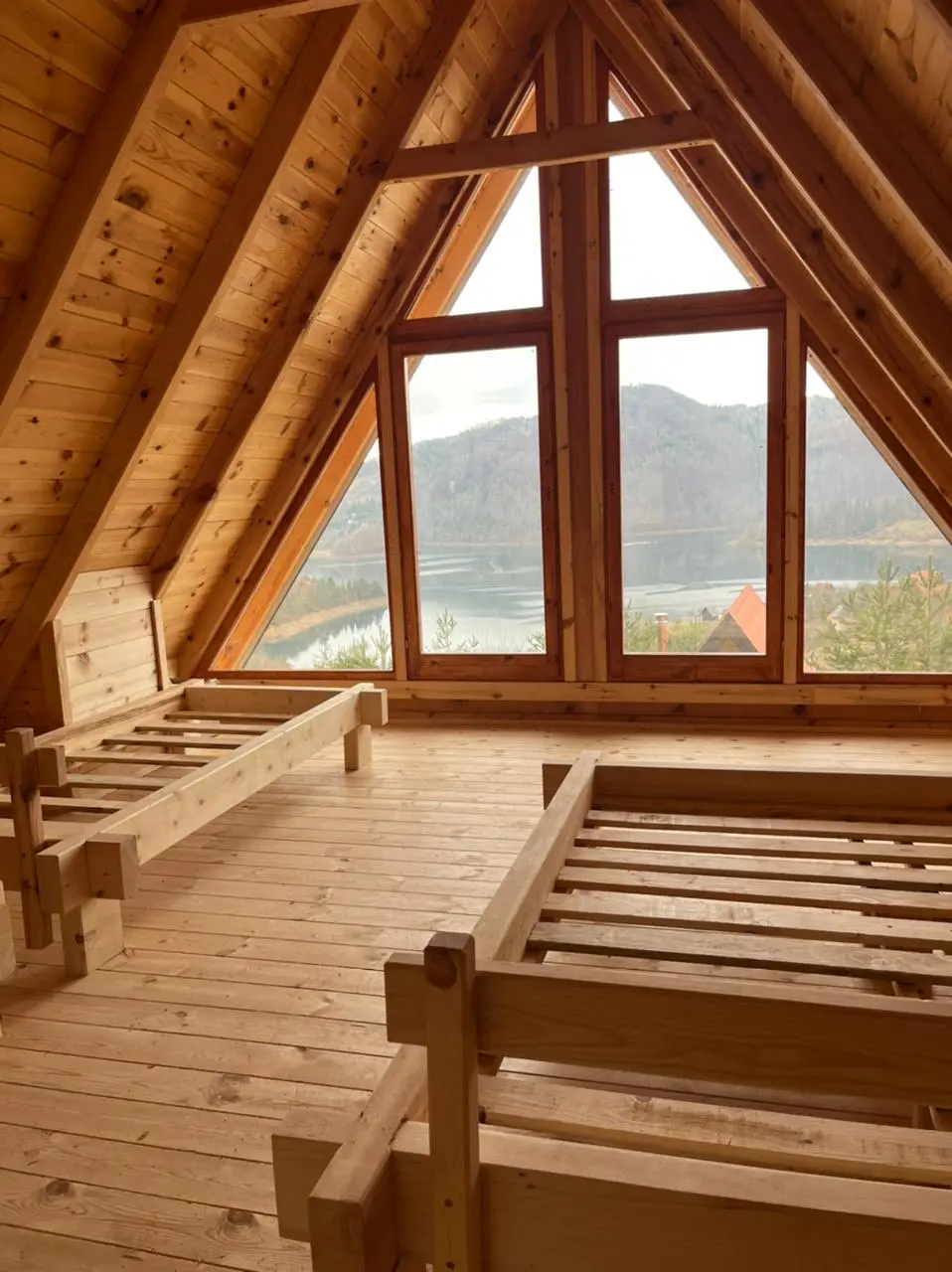 Potkrovlje A-frame kuće sa velikim trouglastim prozorom, tokom završnih radova