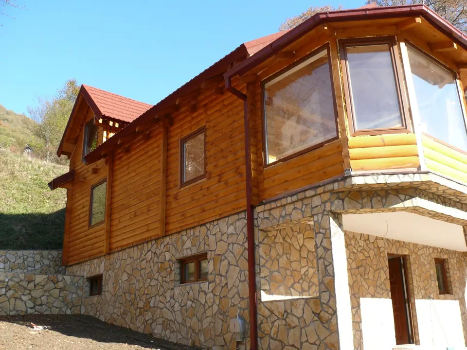 Log house on a stone base with a bay window
