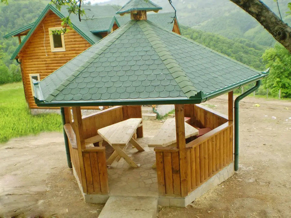 Log cabins and a gazebo on a meadow