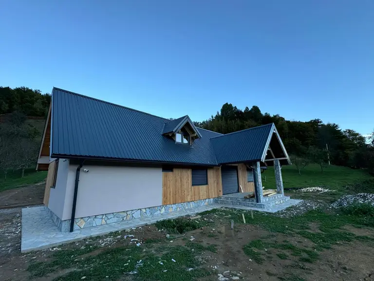 Prefab house with a dark metal roof in the early evening