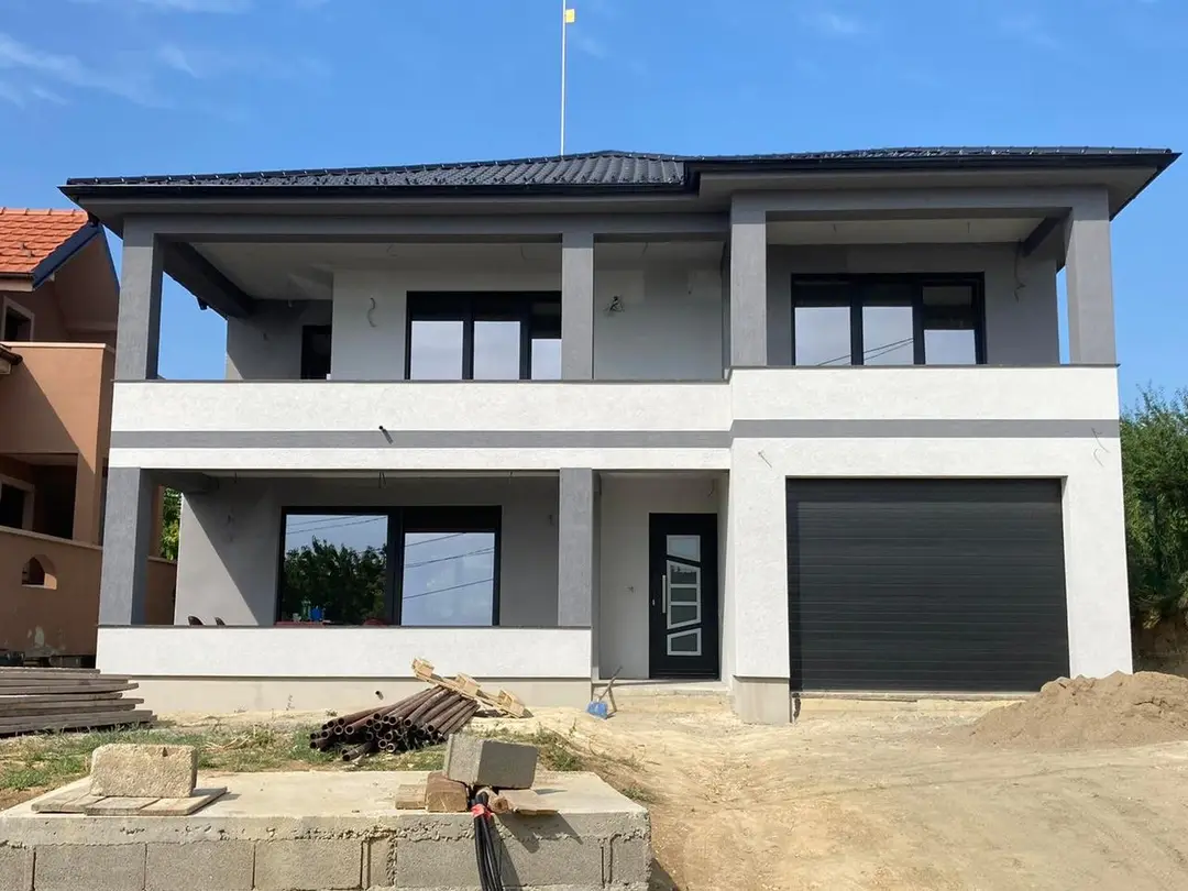Two-storey prefab house with a garage and terraces, grey and white facade