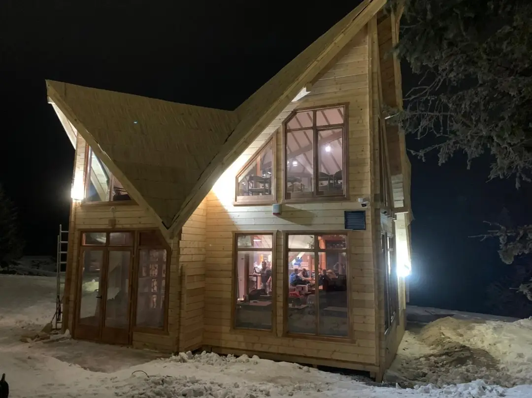 Wooden house with multiple gables lit at night