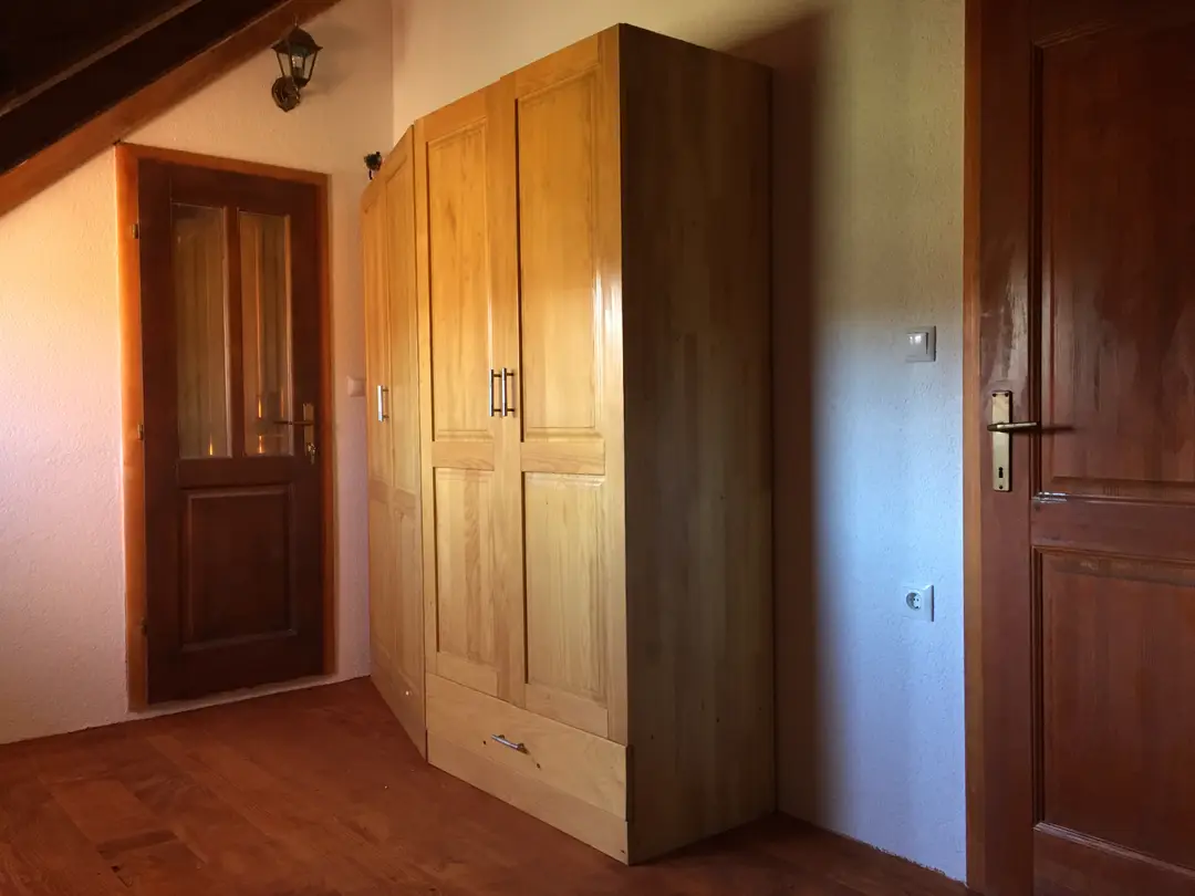 Hallway of a log house with wooden doors and a built-in wardrobe