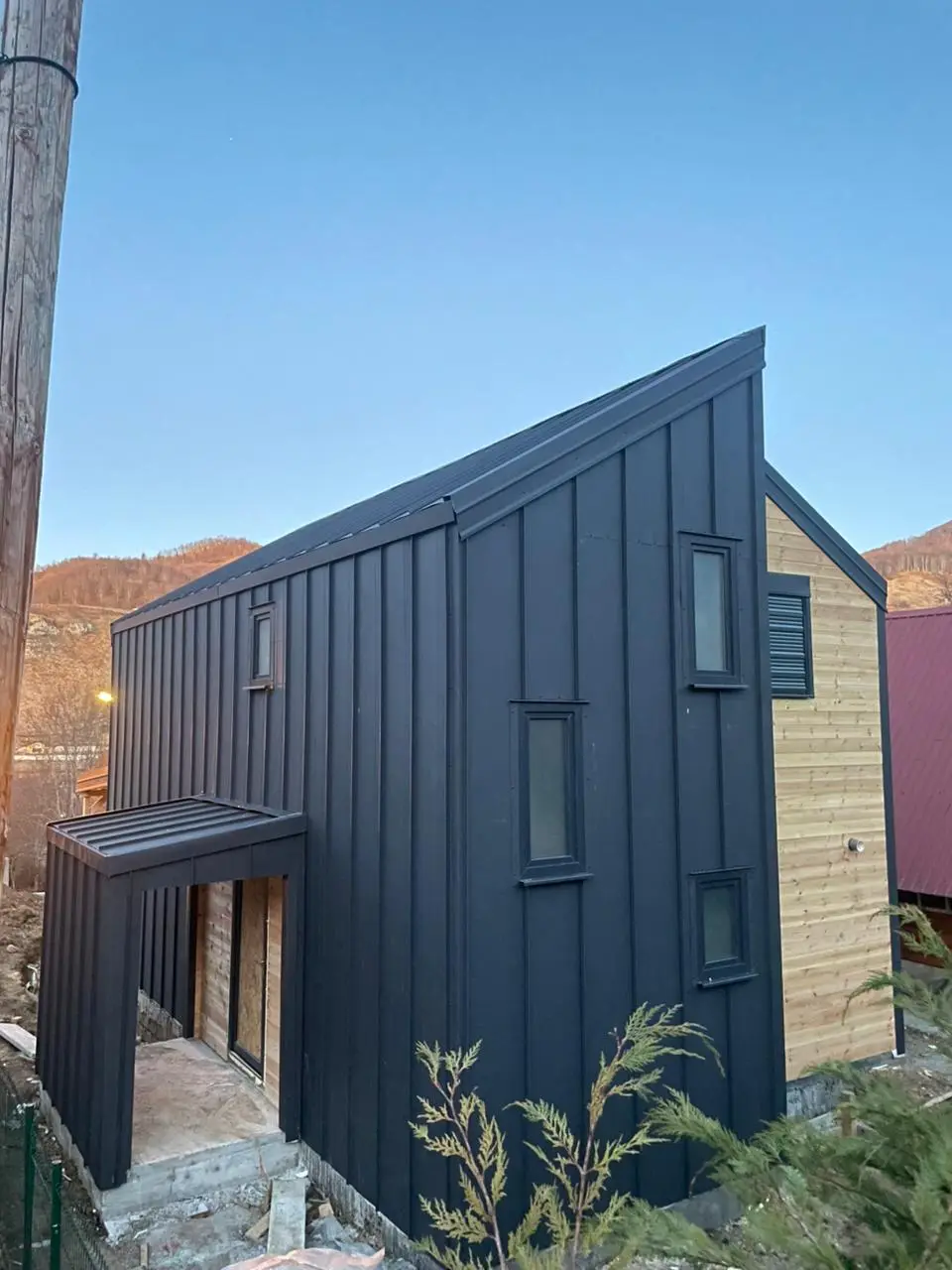 Modern black metal house with an entrance canopy