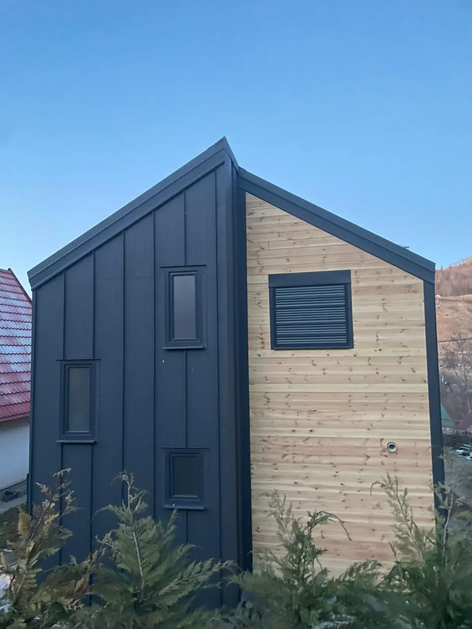 Gable of a modern house with timber cladding and narrow windows