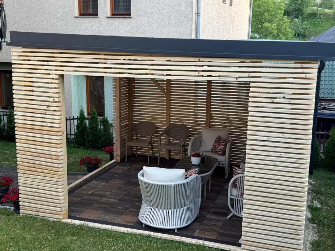 Inside the pergola with armchairs on a paved floor