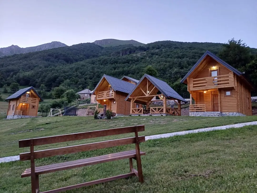 Naselje brvnara u planini sa drvenom klupom u prvom planu