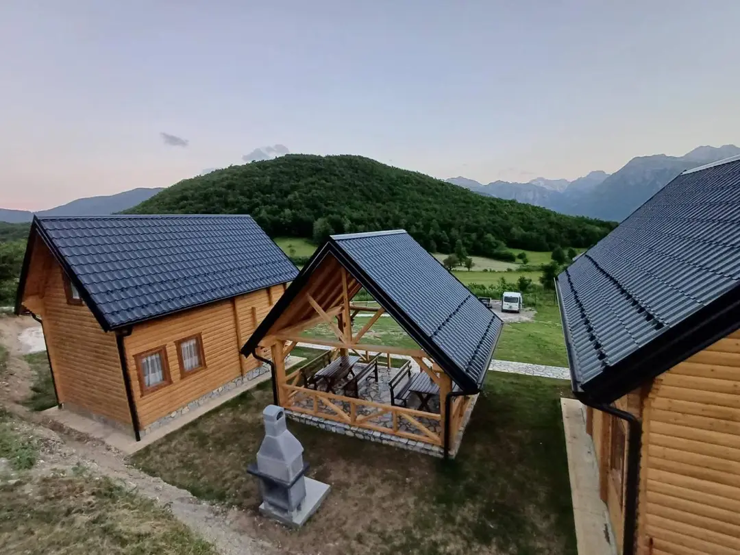 Brvnare i drvena sjenica sa roštiljem između njih