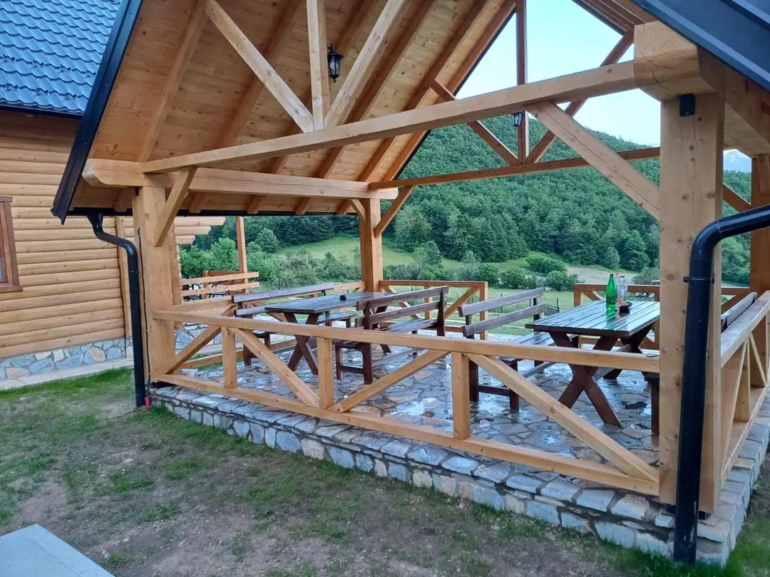 Covered wooden terrace with tables and benches