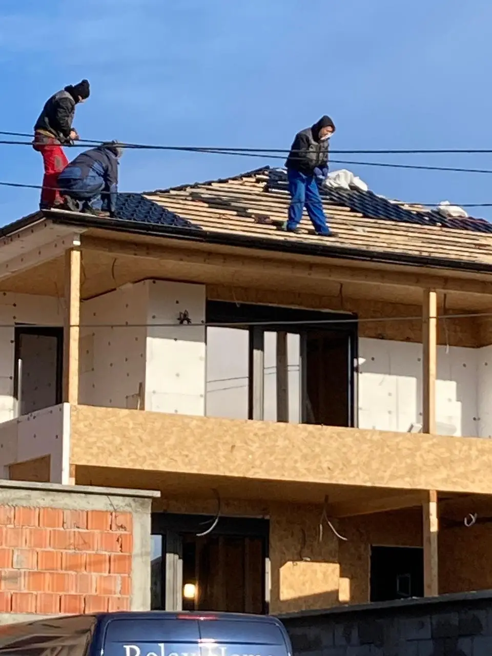Builders installing the roof on a two-storey house