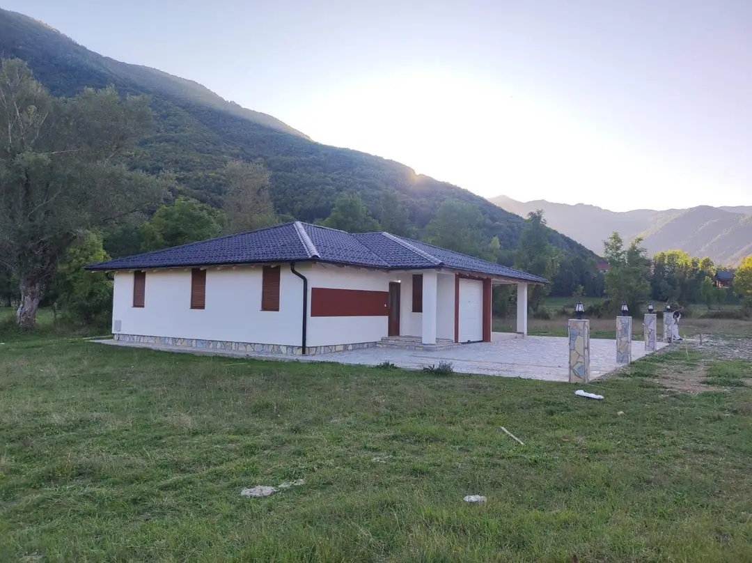 Single-storey prefab house with a garage in a valley below a mountain
