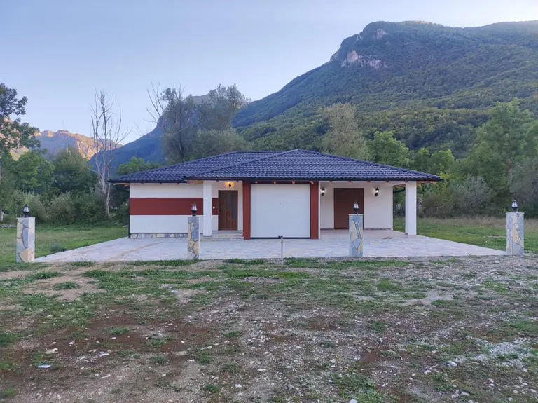 Prizemna montažna kuća sa garažom i ogradom, ispod planine