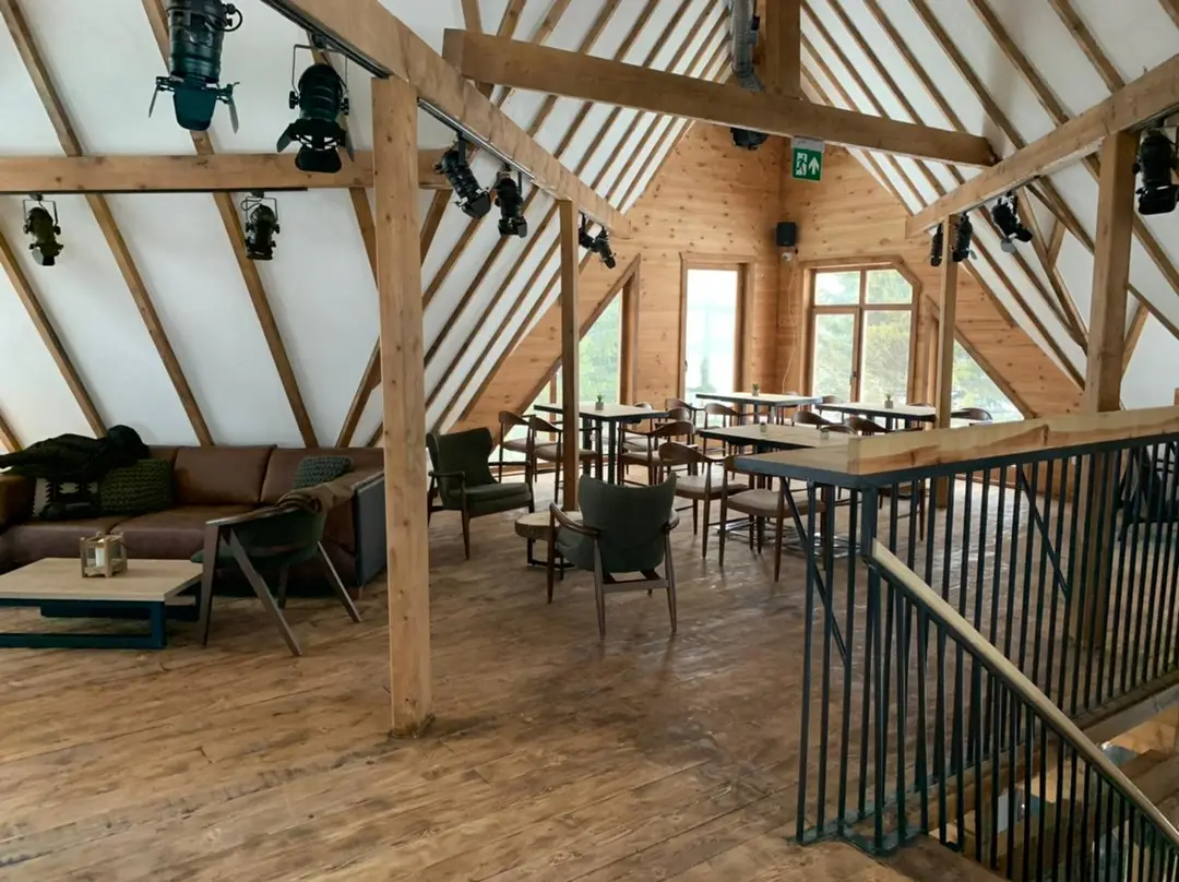 Restaurant interior with an exposed timber roof structure and tables